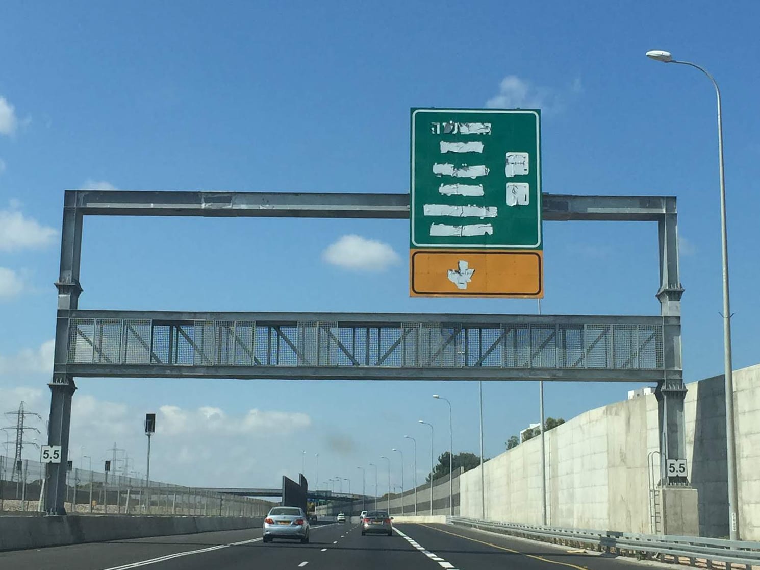 Israeli highway sign with text covered in white